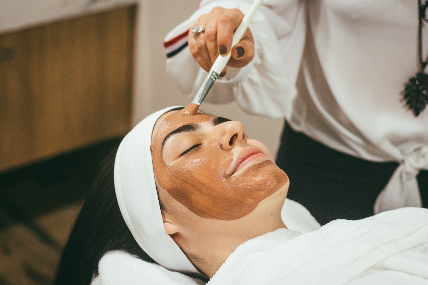 Mulher recebendo tratamento facial em ambiente de clínica de estética